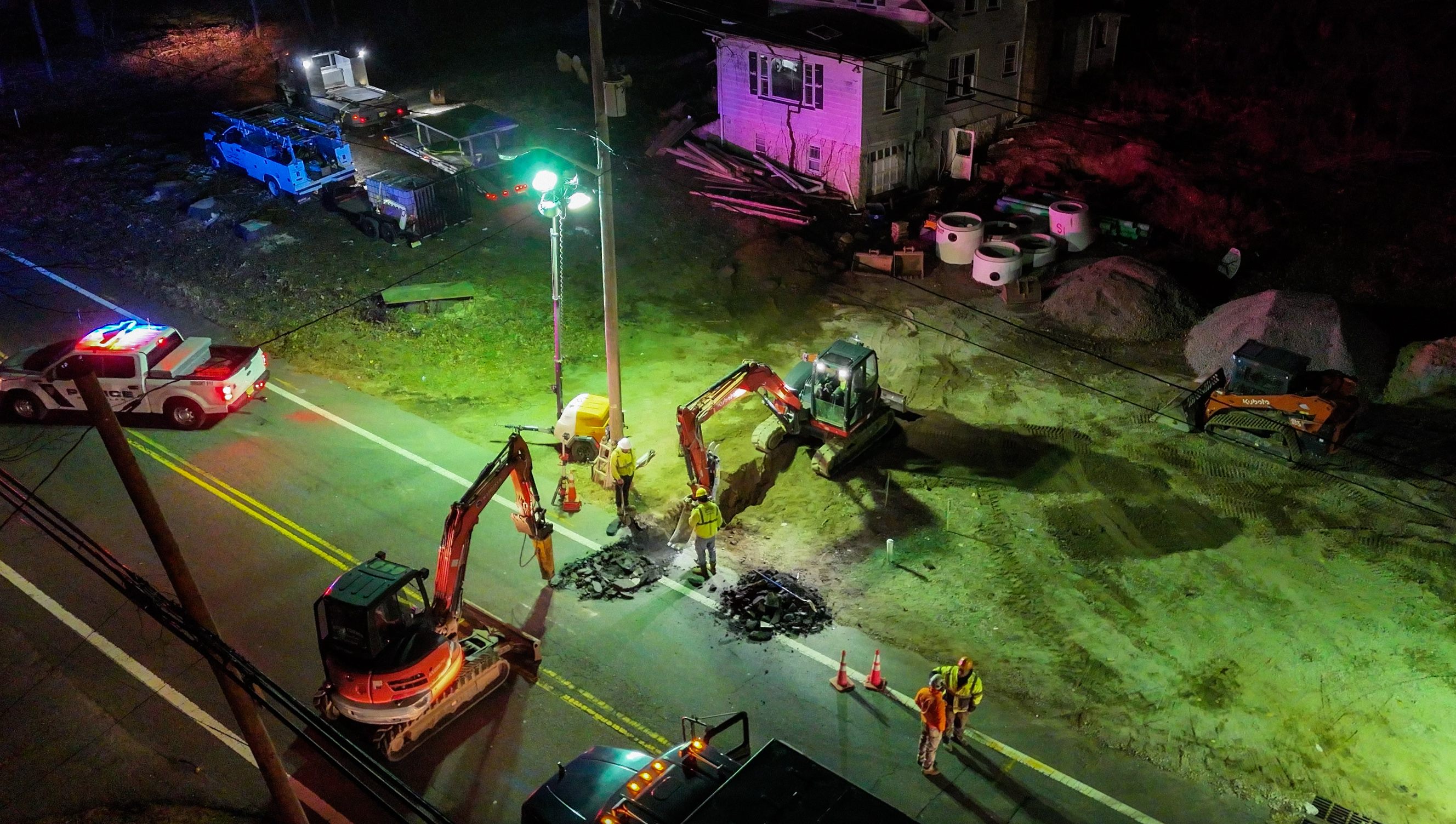 Aerial night view of multi-equipment excavation project in NJ