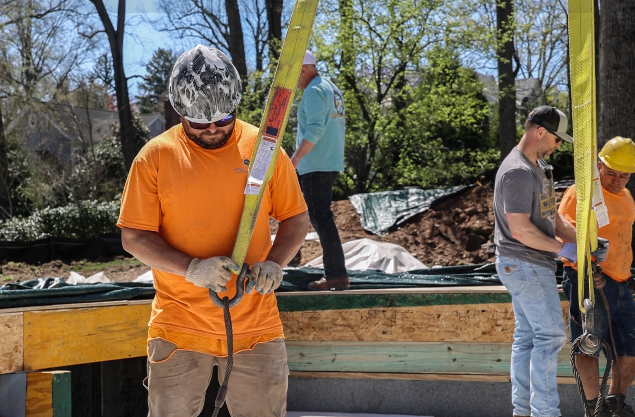 Crew rigging structural planks on residential project