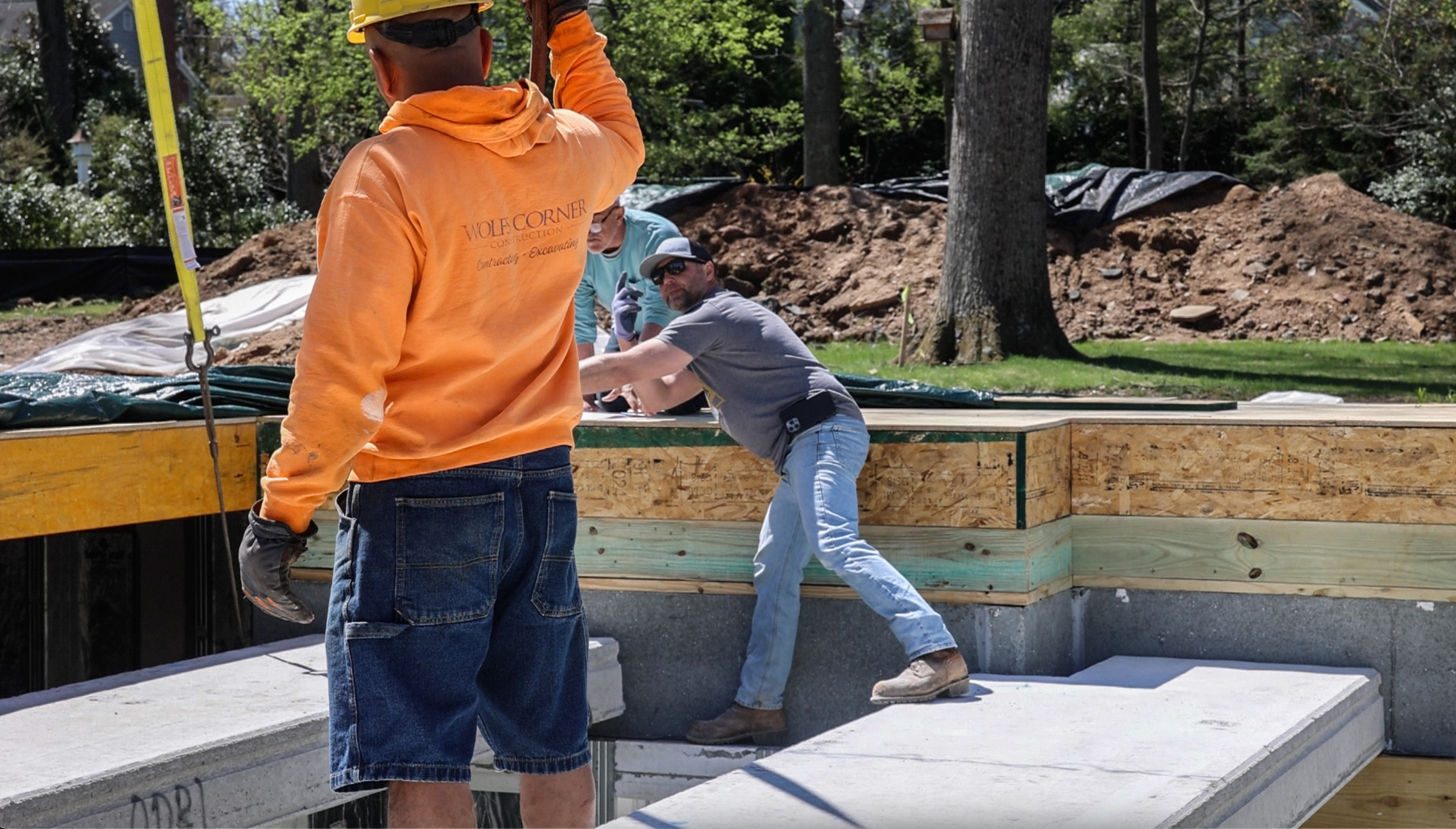Workers coordinating foundation panel placement