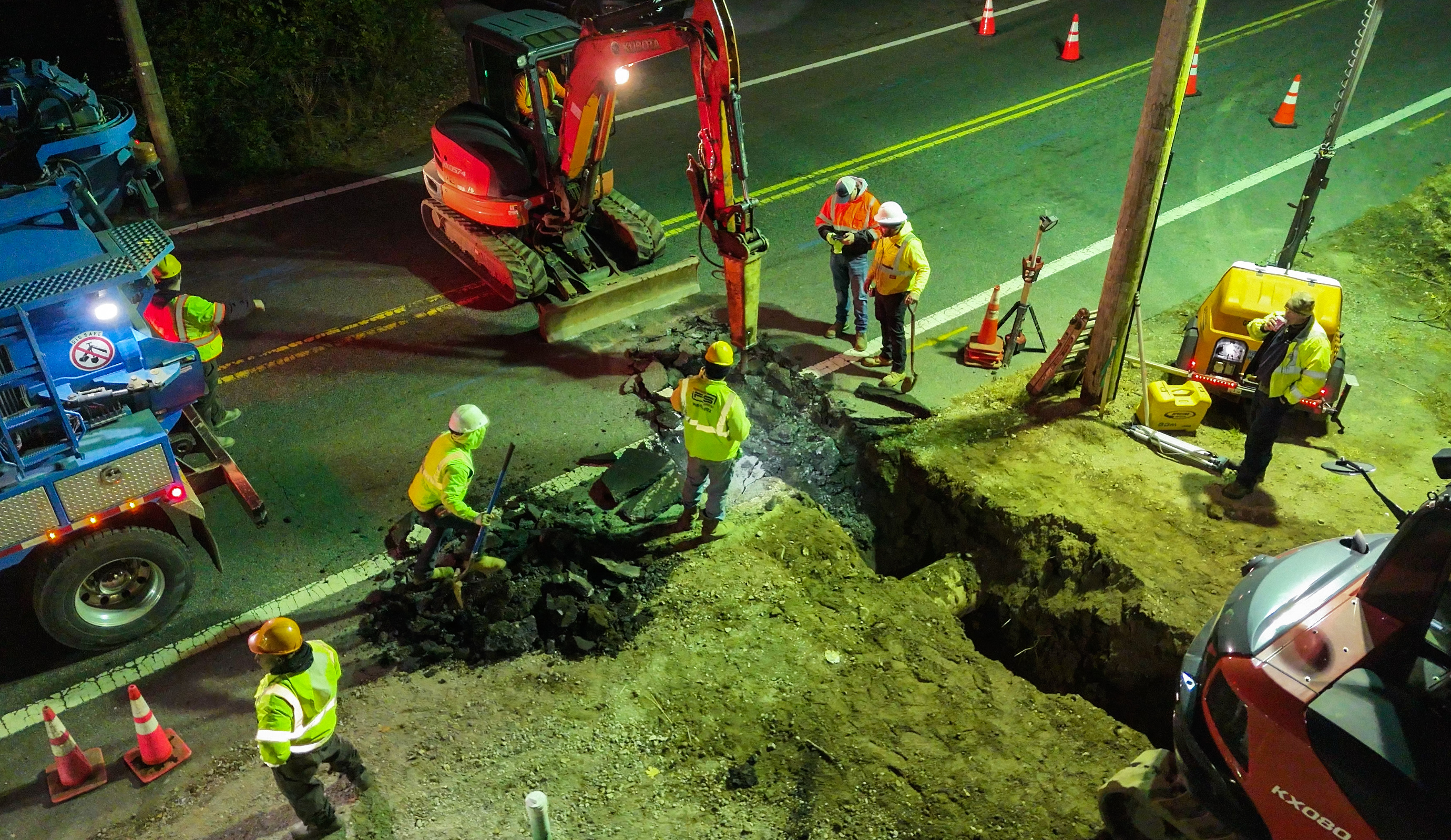 Crew working road excavation with multiple machines